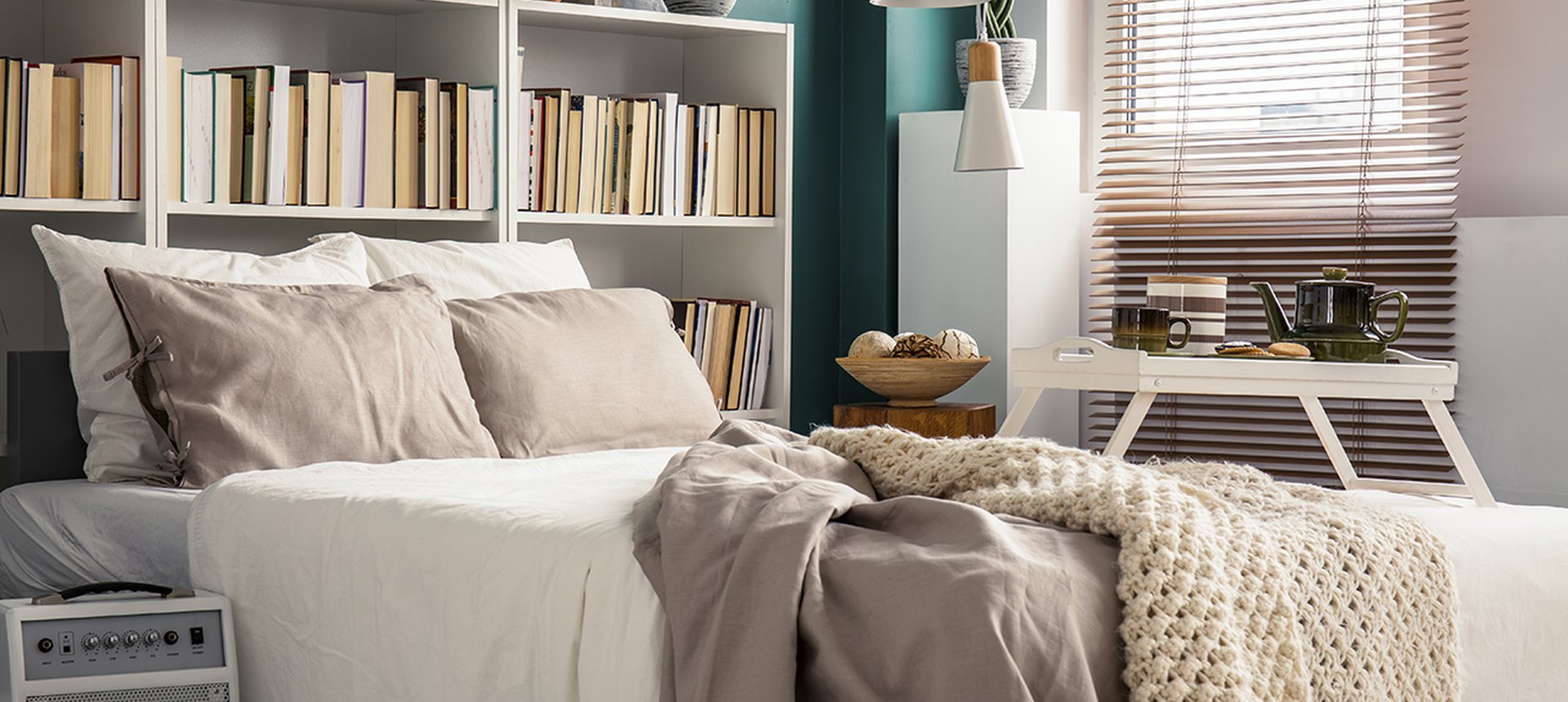 Creative use of small space in a stylish bedroom interior with designer decor and cozy white and beige bedding